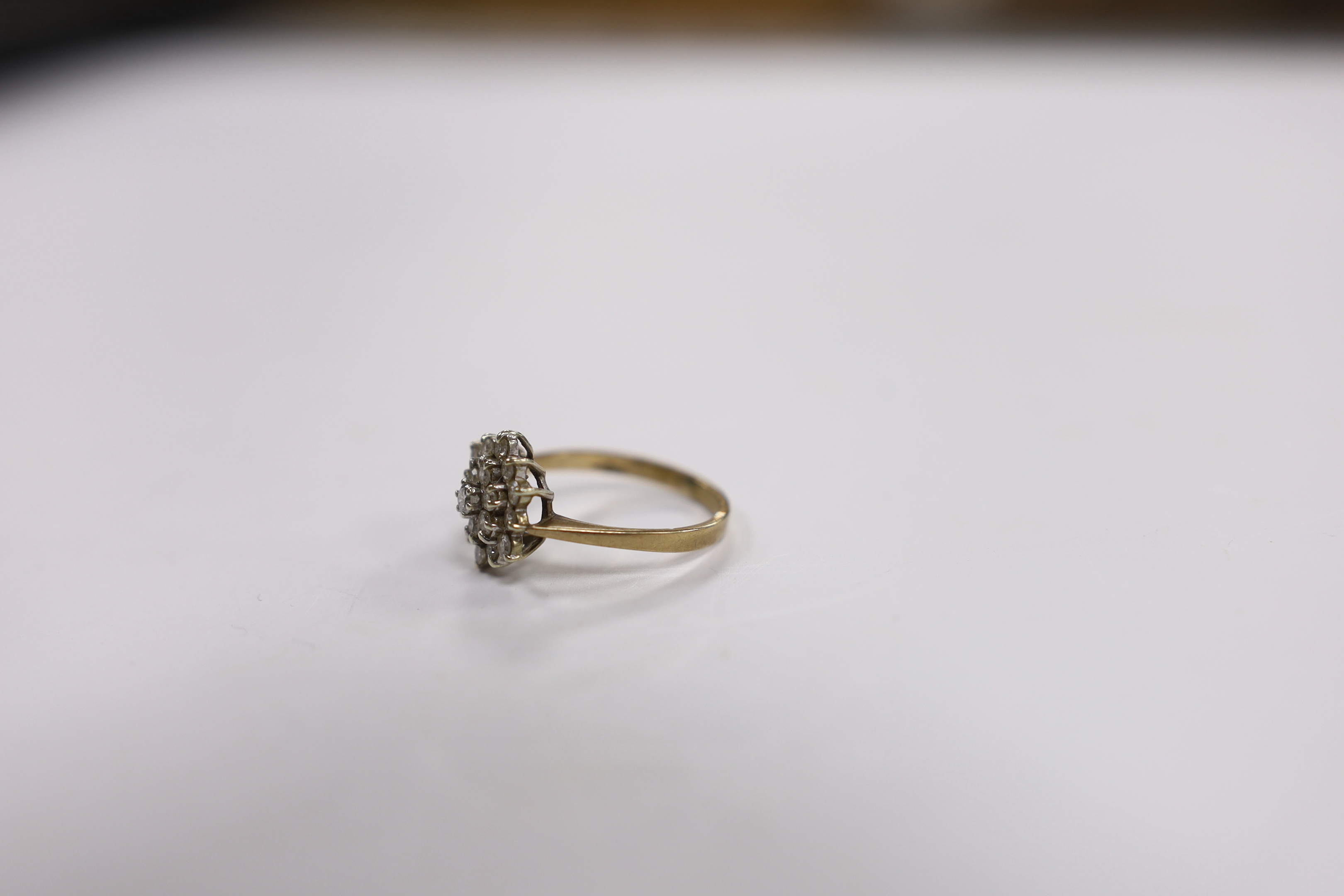 A modern 9ct gold and diamond cluster set flower head ring, size P/Q, gross weight 2.9 grams.